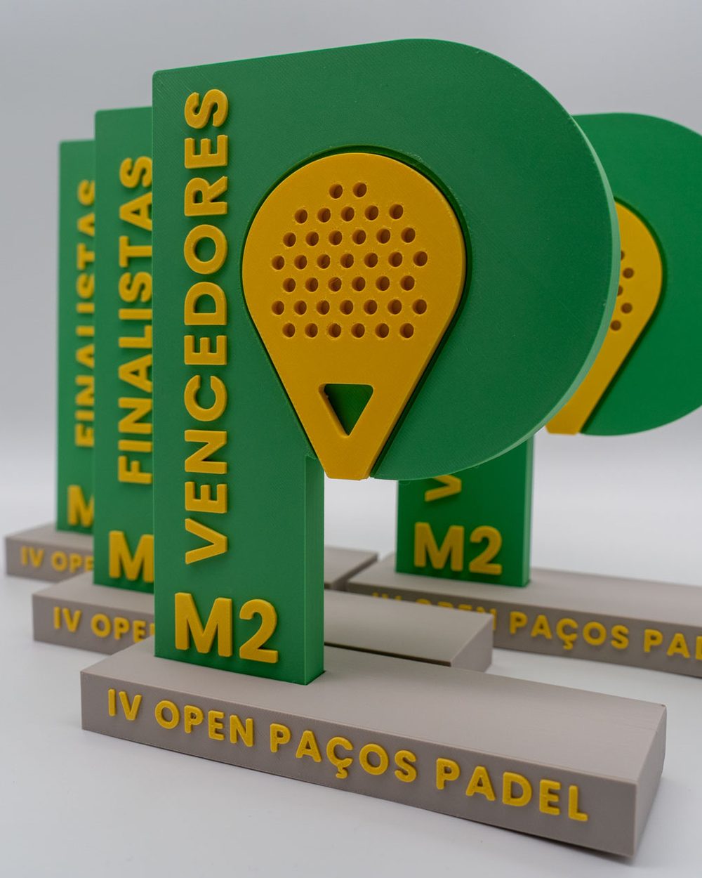Troféus do IV Open Paços Padel em verde e amarelo, vencedores e finalistas
